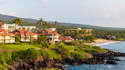 Panoramic Aerial view of beachfront vacation homes and condos along coastal landscape in Wailea-Makena Maui Hawaii during golden hour sunset