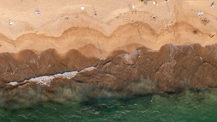 Birds eye view of Wailea beach with beachgoes and water waves along coastal landscape in Wailea-Makena Maui, Hawaii during golden hour sunset