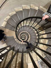 High angle view looking down a deep spiral staircase with metal railings
