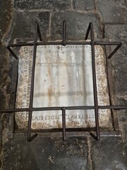Rome, Italy &ndash; 14 January 2025. A faded marble slab in the Church of Domine Quo Vadis bears near-erased footprints traditionally linked to Jesus, enclosed by iron bars and Latin script.