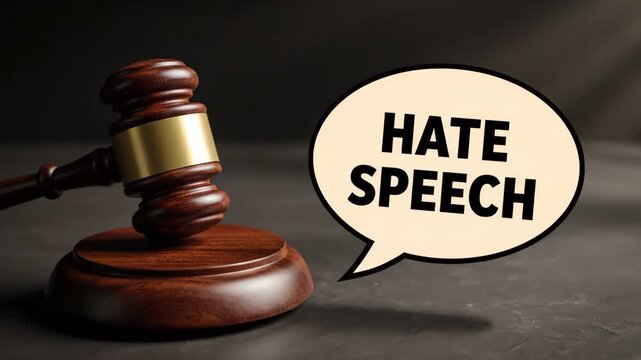 A wooden gavel and base sit on a dark, textured surface, with a cartoon speech bubble reading "Hate Speech", highlighting against hate concepts.