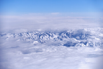 Caucasus mountains with snow peaks in aerial winter scene. Aerial view from plane.