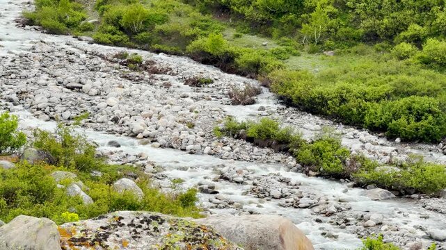 4K Landscape shot of a river stream flowing in the mountain valley as seen from Sural Bhatori in Pangi Valley of Chamba district, Himachal Pradesh, India. Scenic natural background with copy space.