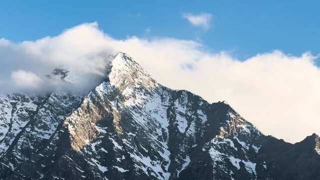 4K Landscape shot of clouds above the snowy Himalayan mountain peak during the winter season as seen from Killar in Chamba district, Himachal Pradesh, India. Scenic view of snowy mountains in winter.