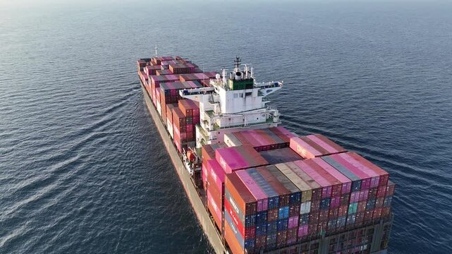 4K Aerial top view of a loaded container cargo vessel traveling over ocean
