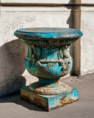 Aged oxidized copper plinth with teal patina, graphic shadow on white exterior wall