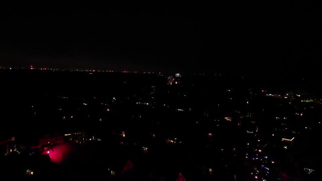Urban scene at night with scattered fireworks and dimly lit buildings in the distance, New Year's Eve 2025, 27798 Hude, Lower Saxony, Germany