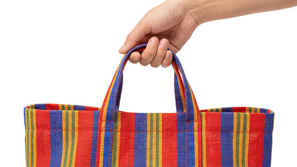 Hand holding colorful striped woven plastic shopping bag isolated on transparent background