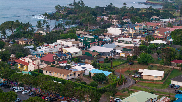 Aerial view of downtown coastal town of Paia, Maui with homes, businesses, and tourist landscapes during evening sunset 