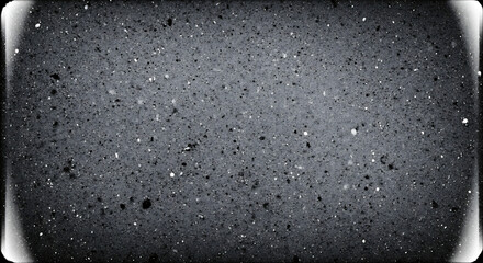 Close-up of a gray textured surface with small black and white speckles and a vignette effect on a white background.