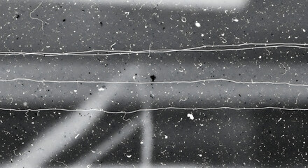 Close-up shot of a weathered, cracked asphalt surface with white paint splatters and lines in a monochromatic color scheme.