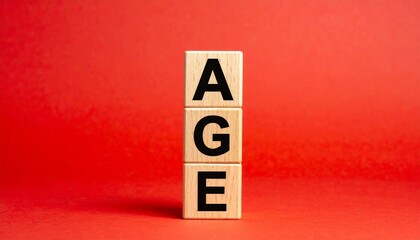 Vertical stack of wooden blocks spelling “AGE” in black on red background, emphasizing time and demographics.