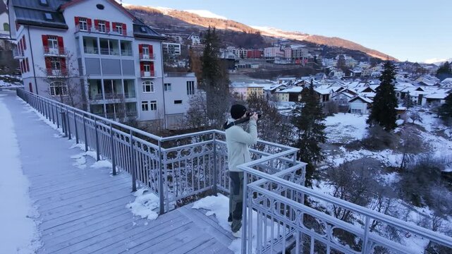 Man Walking Across Icy Bridge in Swiss Alpine Village During Winter &ndash; Snowy Mountains, Rural Switzerland and Cold Seasonal Atmosphere