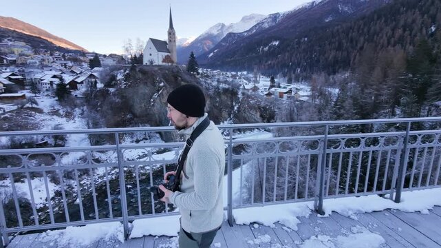Man Walking Across Icy Bridge in Swiss Alpine Village During Winter &ndash; Snowy Mountains, Rural Switzerland and Cold Seasonal Atmosphere