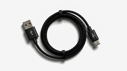 A black USB cable coiled on a white surface viewed from directly above.