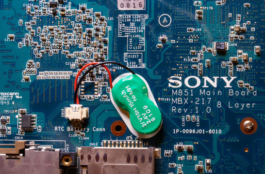 Internal computer motherboard displaying circuits capacitors and connectors essential for power distribution and bios memory function.