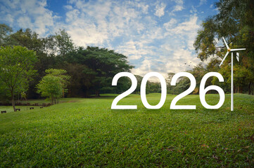 2026 white text with wind turbine on green grass field and trees in public park, Happy new year 2026 green ecology and saving energy concept