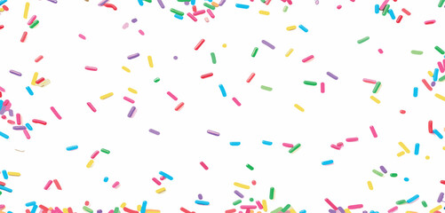 Colorful sprinkles scattered randomly against a clean white background viewed from directly above