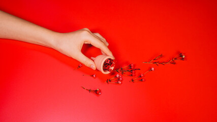 Menstrual Cup with Red Flowers on Red Background Concept Period Flow