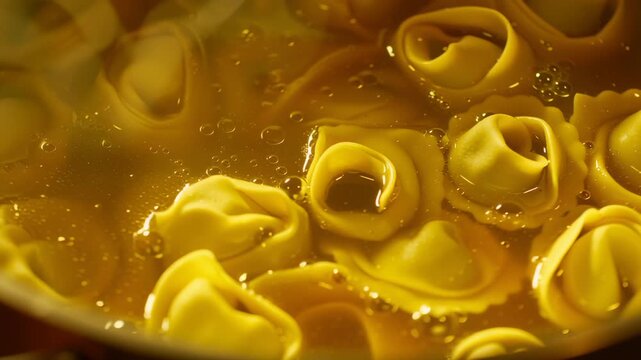 A pot filled with tortellini cooks slowly in warm, inviting kitchen light. The golden pasta swirls in bubbling broth, creating a delicious and comforting atmosphere
