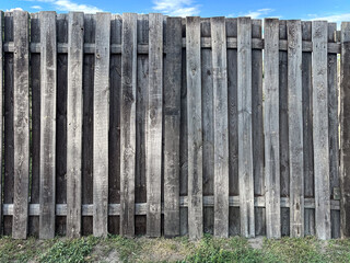A rustic wooden fence with vertical planks.