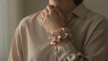 Hand adjusting shirt collar with ruffled cuff