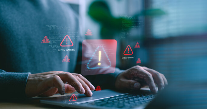 Close-up of hands typing on laptop with digital system warning icons. Concept of cybersecurity alert, software error, system failure, online threat detection in digital environments. - Powered by Adobe
