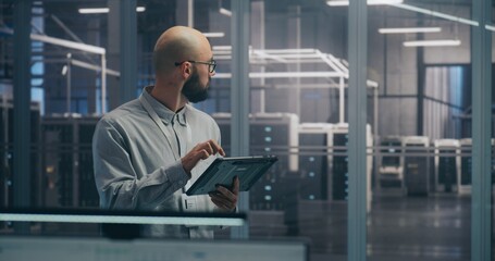 On Site Coordination, IT Specialist Using Tablet to Diagnose Rack Status. Focused IT Professional Diagnoses Server Rack Status Using Mobile Tablet Device. Coordination and On Site Troubleshooting.