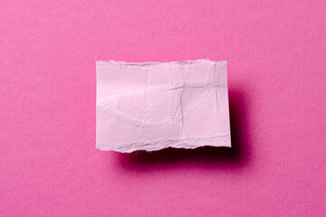 One single torn ripped wrinkled crumpled blank paper note with shadow and copy space for text on pink background