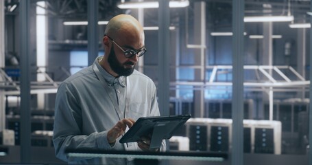 Technician Using Tablet For Asset Management in Data Center. Man Check Assets in Server Hall....