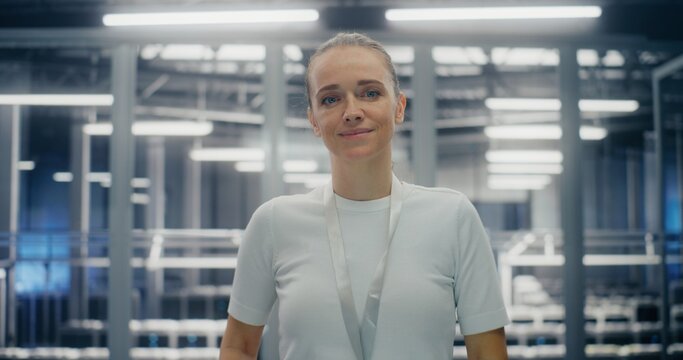 IT Infrastructure Professional, Dedicated Engineer Smiling Warmly. Woman Standing in Large Scale Server Room. Concept of Gender Diversity and Success in High Tech Corporate Environment. Portrait.