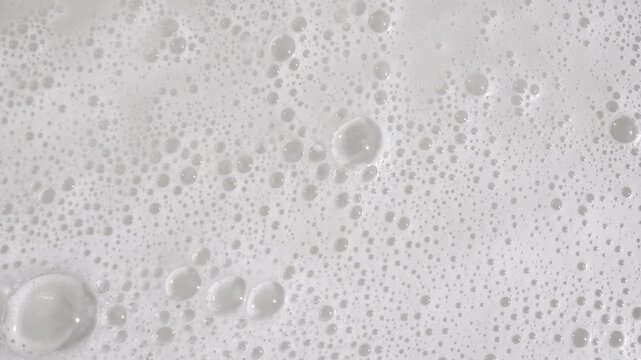 Texture of white soap foam with bubbles abstract background. Soap sud macro structure. Bathtup Soap Foam. Natural White Shampoo Bubbles Motion. High quality 4k footage