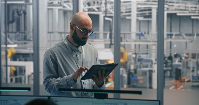 Technical Specialist, Using Table Monitor Status and Performance of Automated Factory Machinery in Clean, Modern Industrial Plant. Concept of Mobile Diagnostics and on Site Process Optimization.