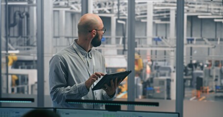 Technical Specialist, Using Table Monitor Status and Performance of Automated Factory Machinery in Clean, Modern Industrial Plant. Concept of Mobile Diagnostics and on Site Process Optimization.