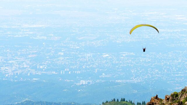A paraglider soars over a stunning mountain landscape. Concept freedom of extreme sports and adventure