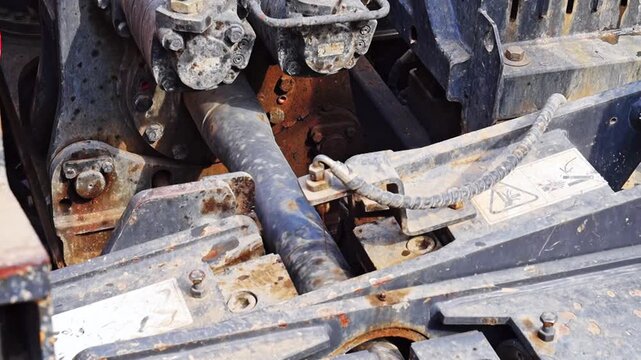 A close-up video showing the horizontal directional drilling rig's working shaft being screwed onto a section of drill pipe to be removed after utility line installation. Industrial tools