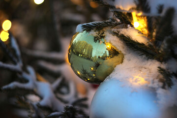 A Christmas tree branch with a toy, snow fell