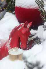 A red toy horse stands near a street cafe. It's a symbol of the New Year.