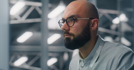 Close Up of Dedicated Engineer Oversees Digital Infrastructure From Workstation. Blue Lit, High...