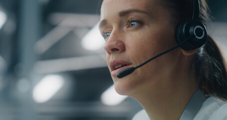 Close Up of Dedicated Female Technician Responding to Real Time System Alerts, Communicating Via Headset at Console in Data Center. Concept of Critical Incident Management and Rapid Response.