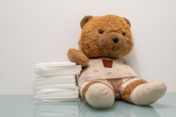 Teddy Bear With Diapers: Soft Plush Toy Surrounded by Stacked Diapers for Cute Nursery Decor