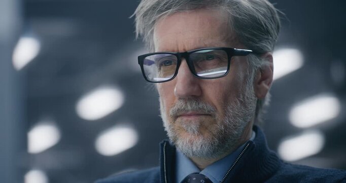 Close Up of Focused, Bespectacled Male Data Analyst Intently Checking Real Time Performance Metrics on Screen in Modern Tech Center. Concept of Data Expertise and System Reliability. Portrait.