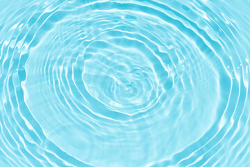 Blue water with ripples on the surface. Defocus blurred transparent blue colored clear calm water surface texture with splashes and bubbles. Water waves with shining pattern texture background.