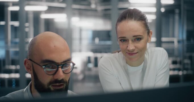 Team Consulting Over Console in Control Room. Digital infrastructure experts consulting over workstation console, deeply engaged in technical discussion. Concept of enterprise level system management.