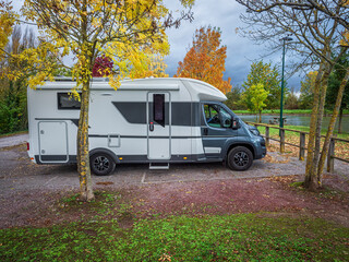 Motorhome parked by river in autumn at Guarbecque, France