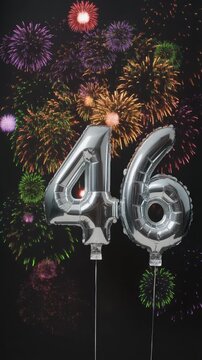 Silver balloon number 46 with fireworks in the background. Festive scene for birthday or anniversary party