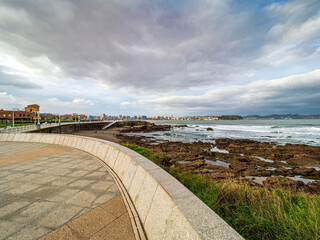 Gij&oacute;n coastline view with city buildings and dramatic sky
