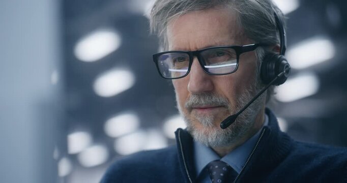 Close Up of Professional IT Director With Glasses Intensely Communicating Via Headset From Modern Data Center. Concept Crisis Management, System Troubleshooting, and Critical Communication. Portrait.