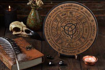 Mystic Wheel of the Year with runes and ritual items on a wooden table. Spiritual and pagan concept.