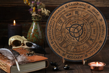 Mystic Wheel of the Year with runes and ritual items on a wooden table. Spiritual and pagan concept.